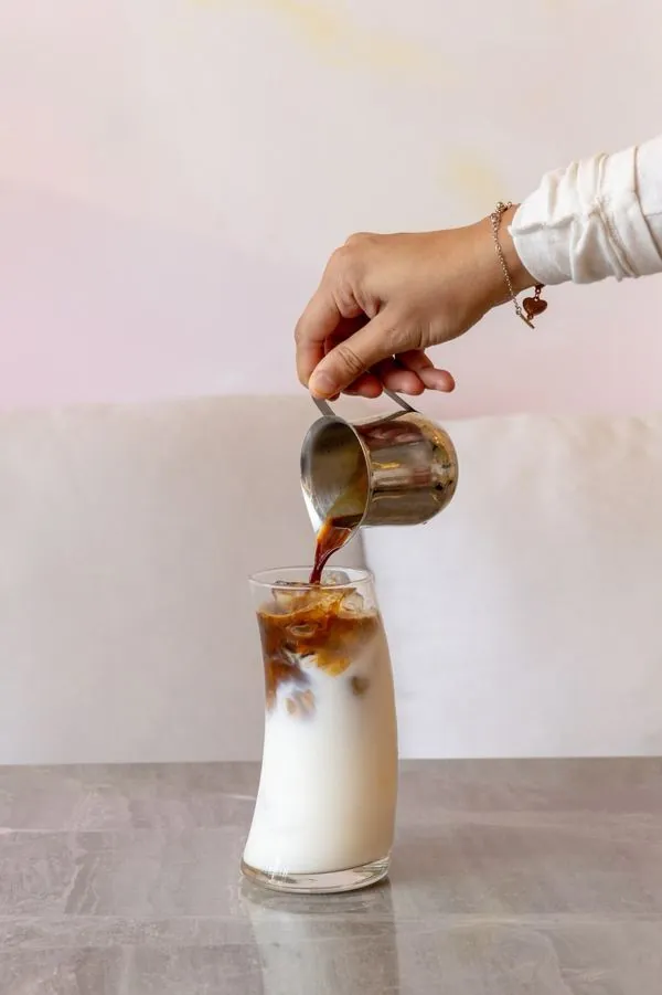 Espresso vertido sobre leche con hielo